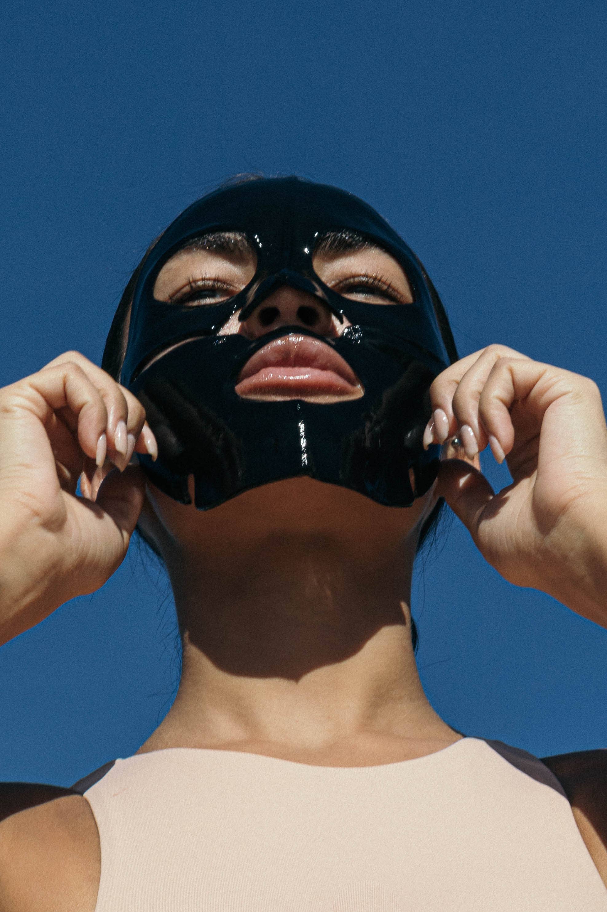 person wearing a black collagen face mask