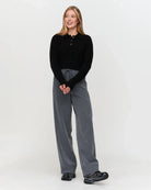 a woman wears a black ribbed knit polo sweater