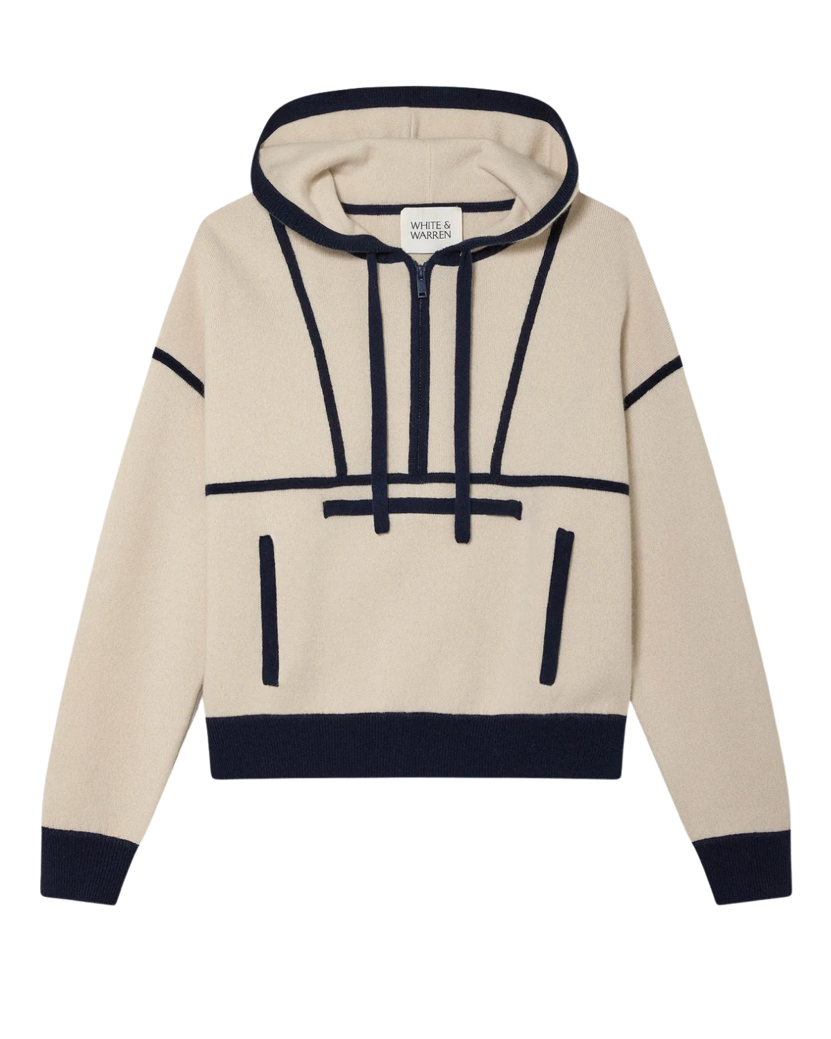 A woman wearing an ivory cashmere hoodie with navy accents