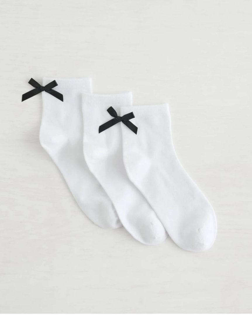 three pack crew socks in white with black bows on the back
