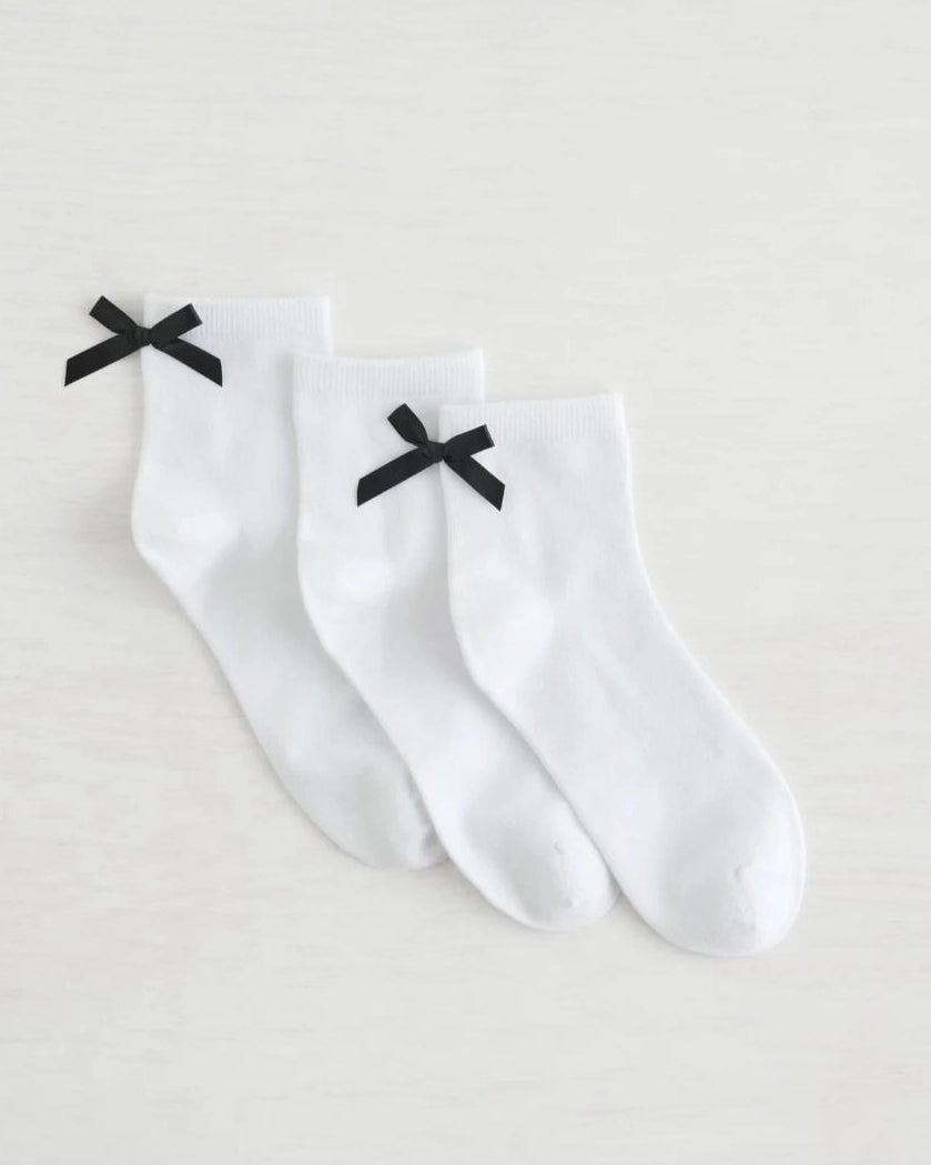 three pack crew socks in white with black bows on the back