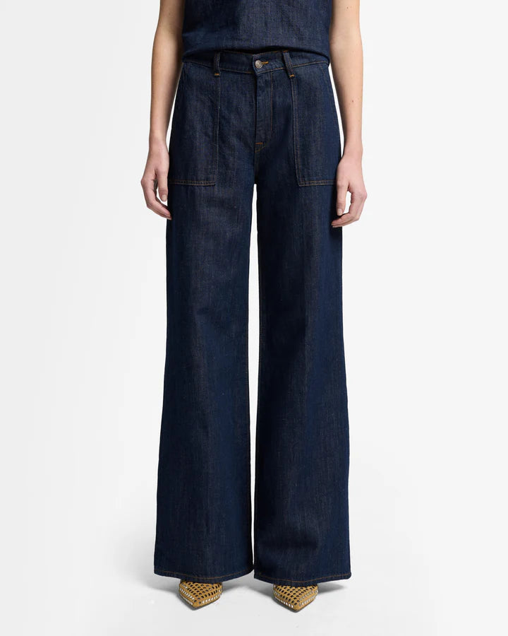 woman wearing dark blue wide-leg jeans by 7 for all mankind with utility pockets