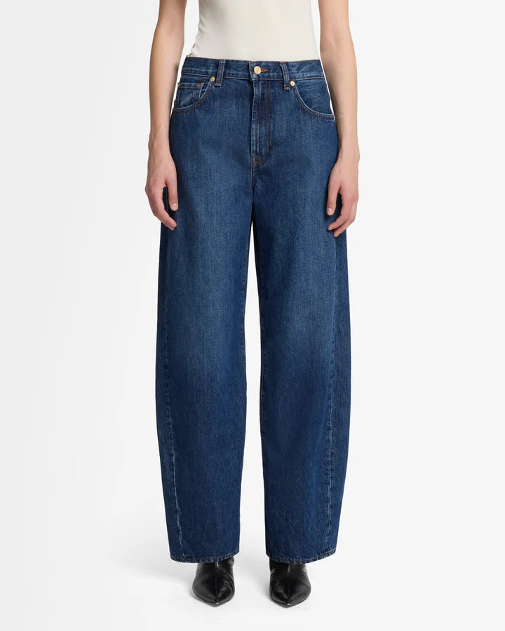 a woman wearing bonnie barrel jeans by 7 for all mankind i