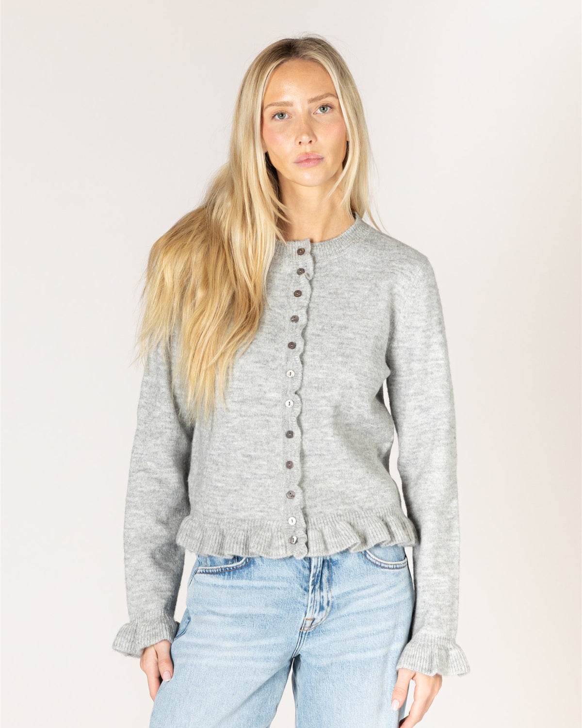 grey cardigan with ruffles down the middle and on sleeves