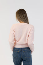 pink wrap sweater with pearls