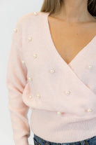 pink wrap sweater with pearls