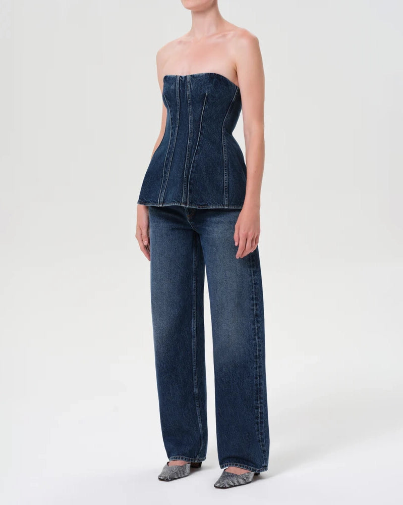 Woman wearing a denim strapless corset top by Agolde