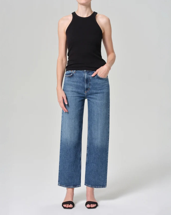 Person wearing mid rise blue jeans in medium wash