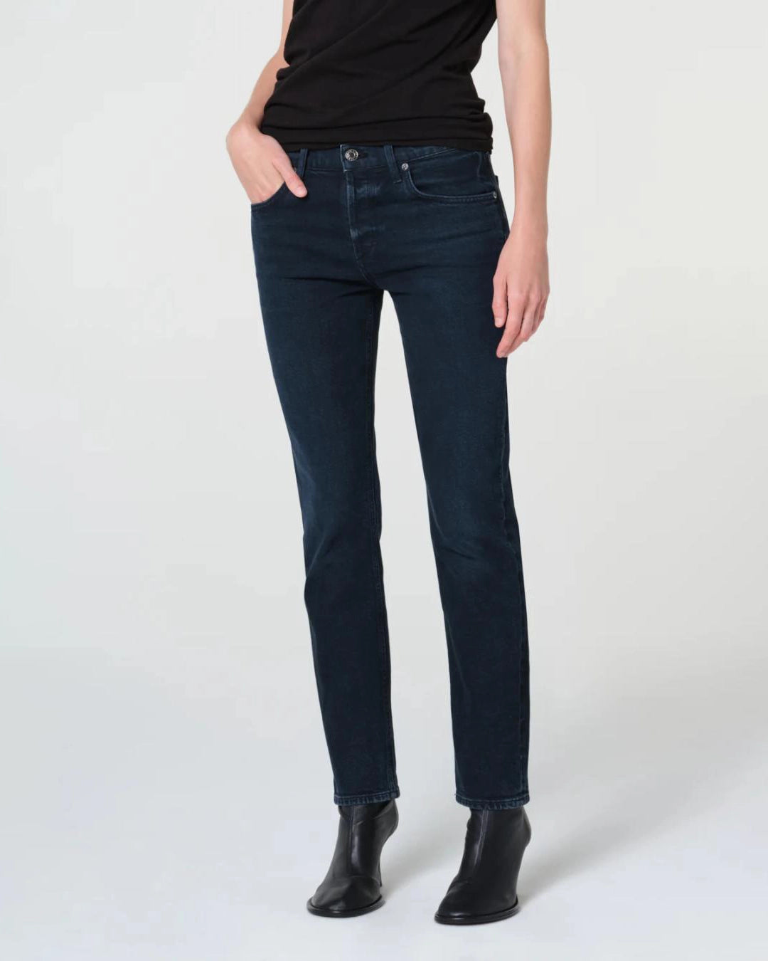 a woman wears a pair of skinny ankle cut dark denim jeans by Agolde