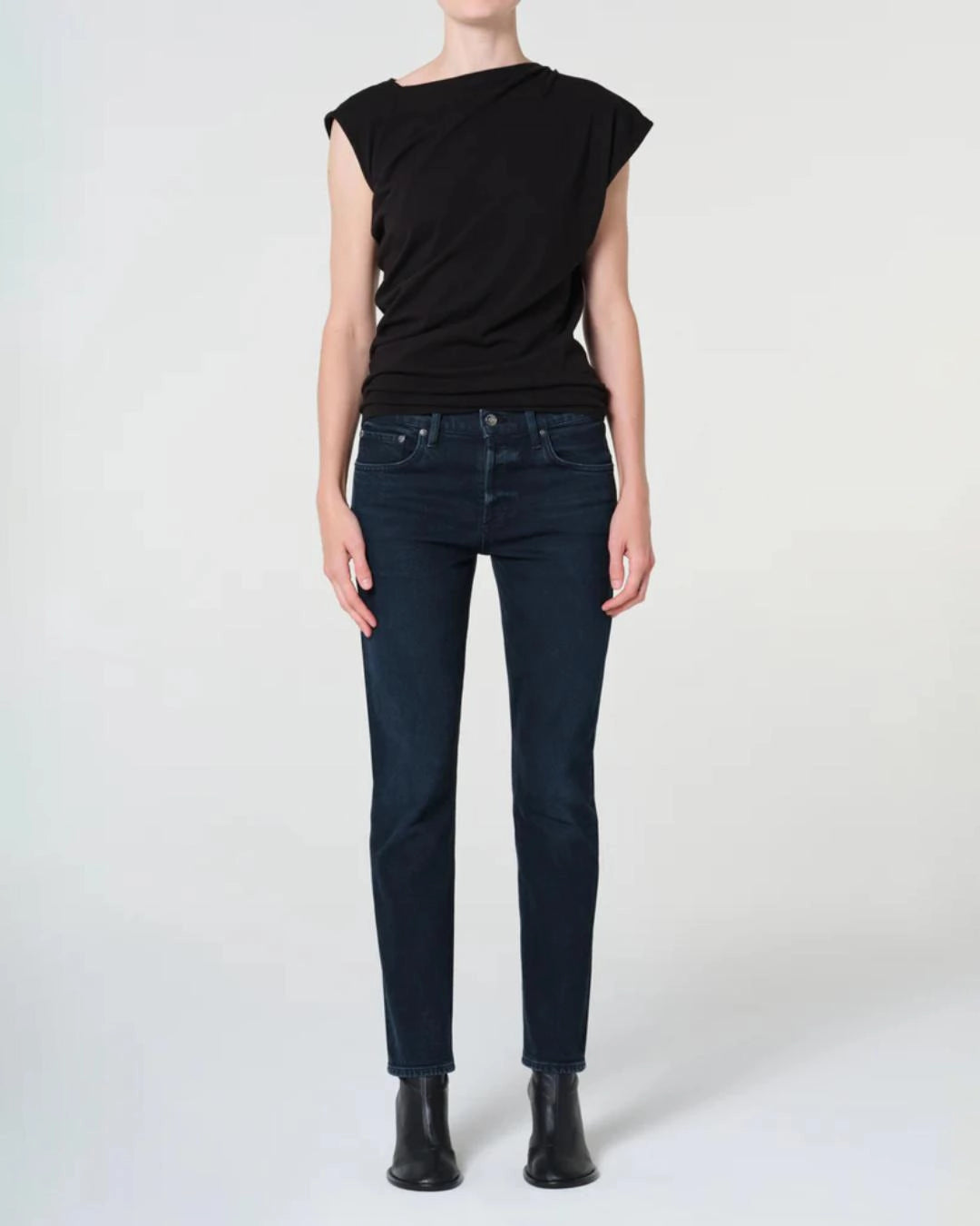 a woman wears a pair of skinny ankle cut dark denim jeans by Agolde