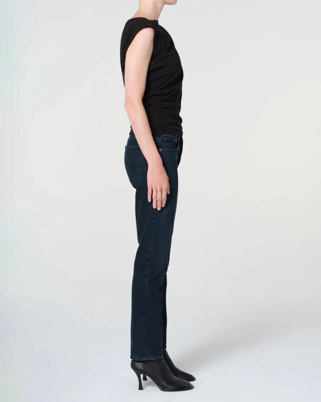 a woman wears a pair of skinny ankle cut dark denim jeans by Agolde