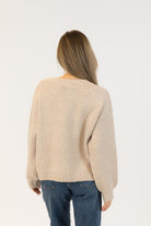 beige sweater with bows on it