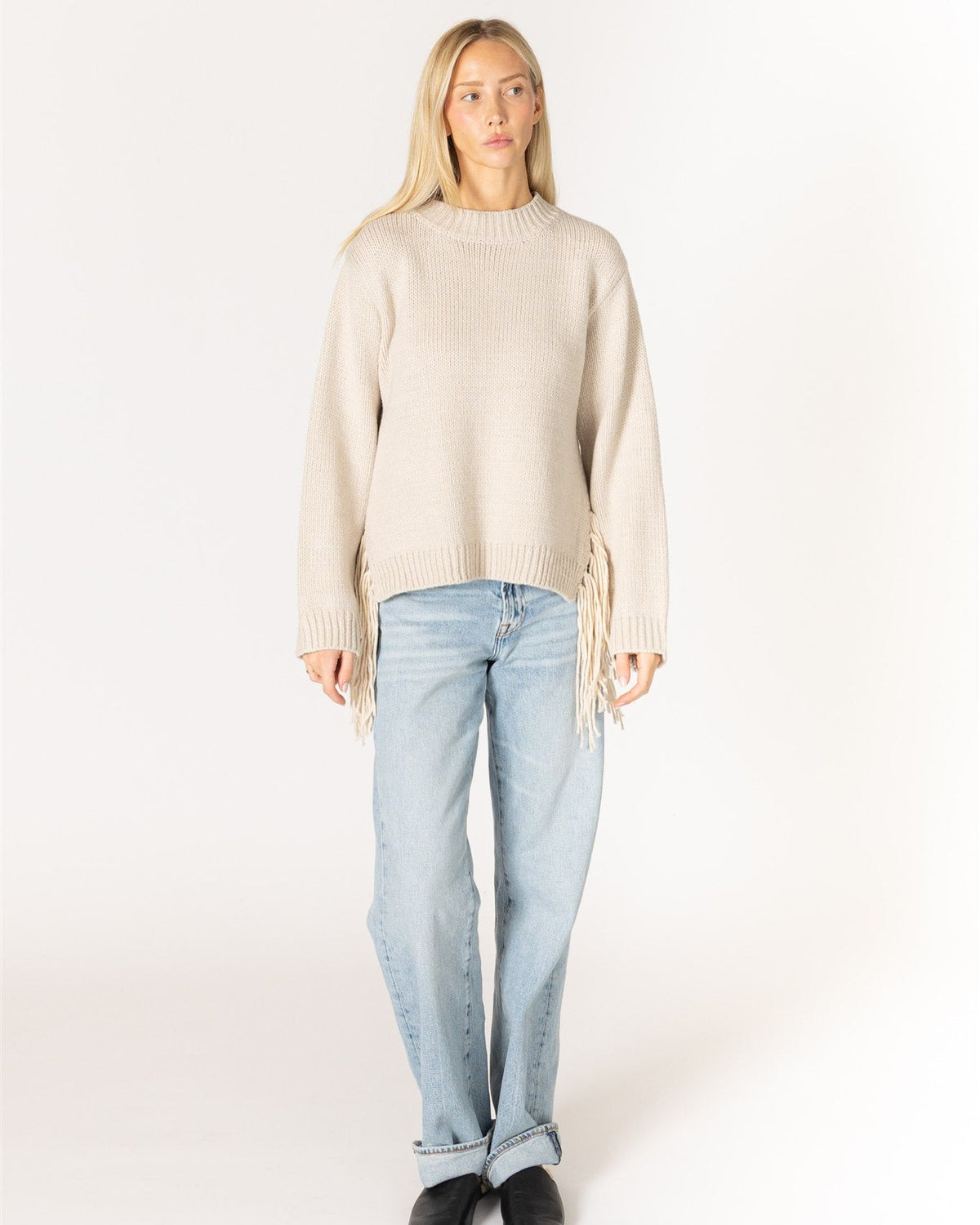 beige knit sweater with tassels on the sides