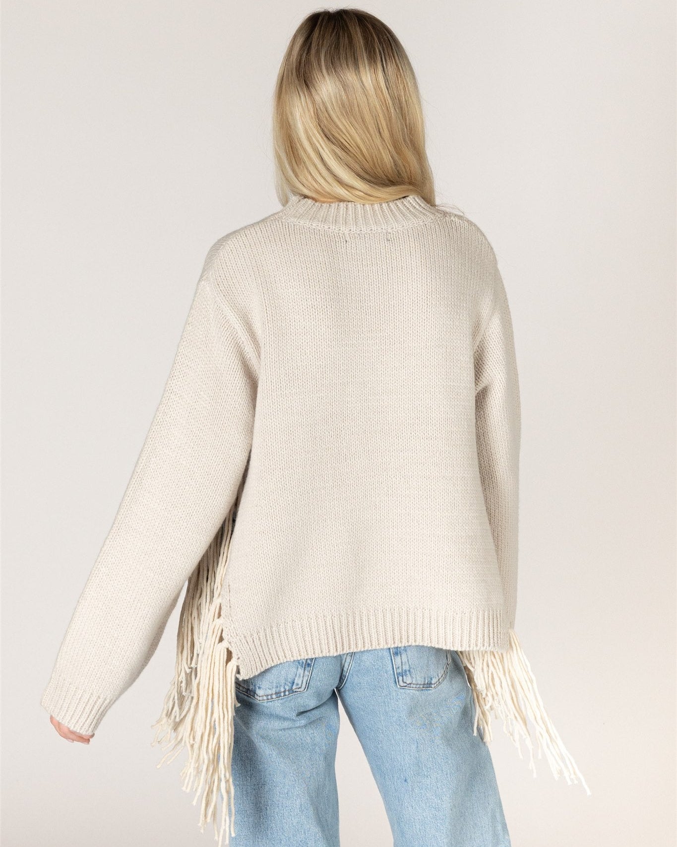 beige knit sweater with tassels on the sides