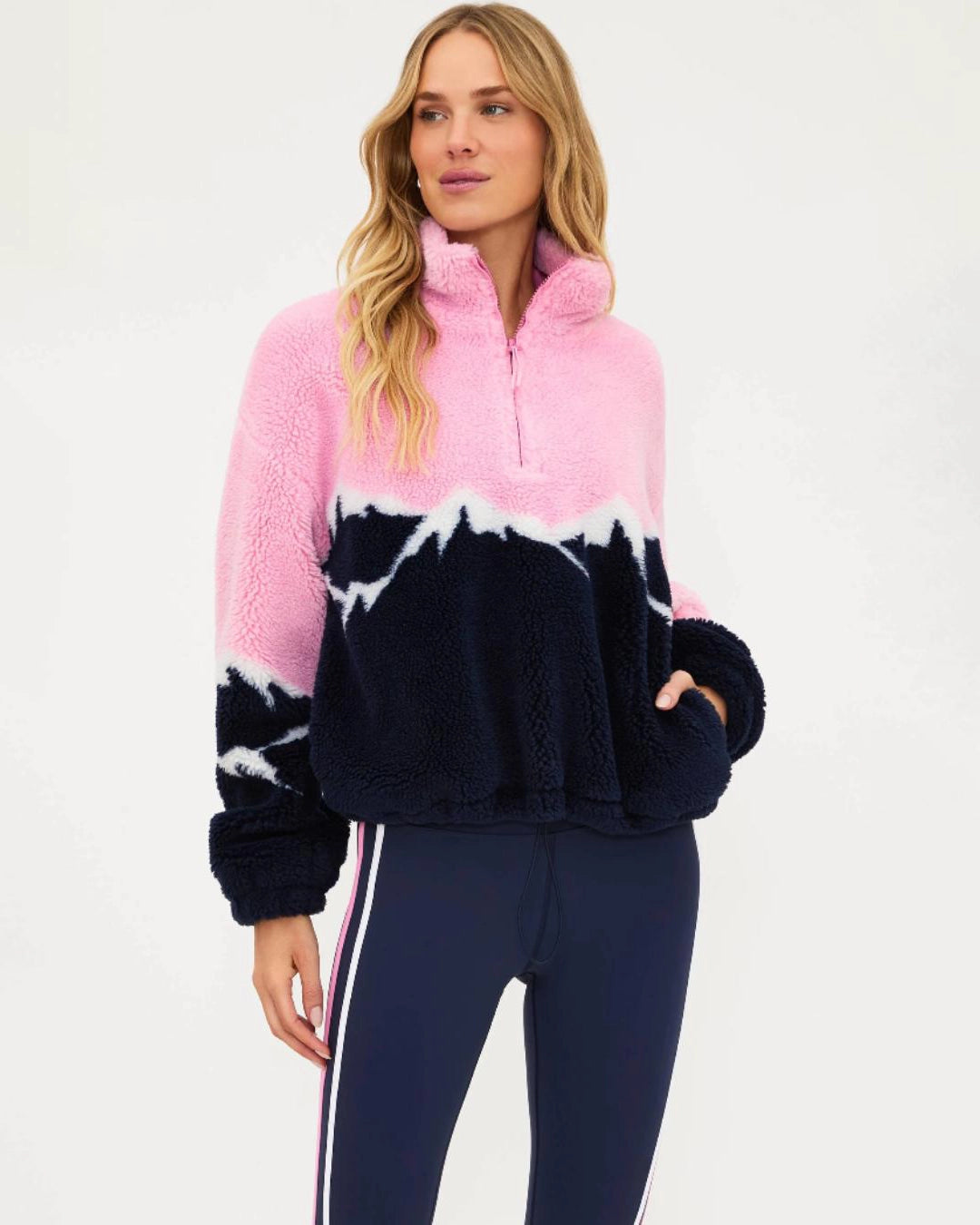 a woman wears a plush sherpa quarter zip sweater in pink with a navy blue mountain top