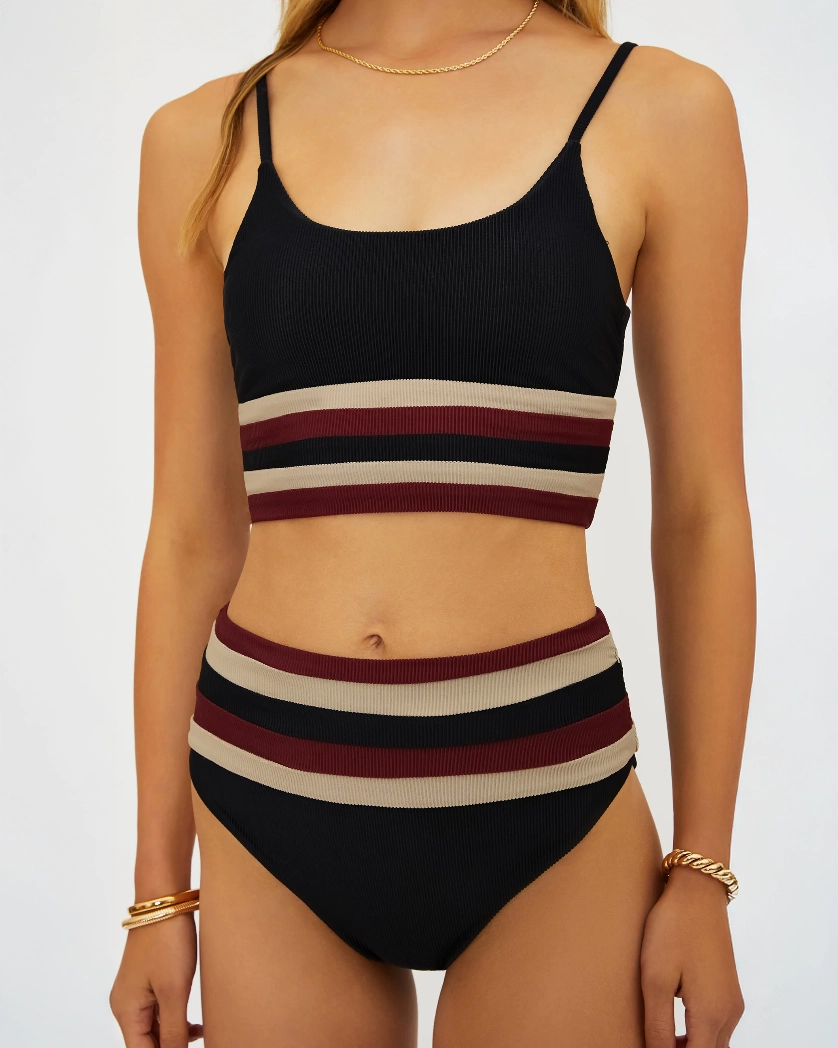 Woman wearing a black and red and beige striped bikini set