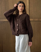 Woman wearing a brown cable knitted cardigan with large horn buttons
