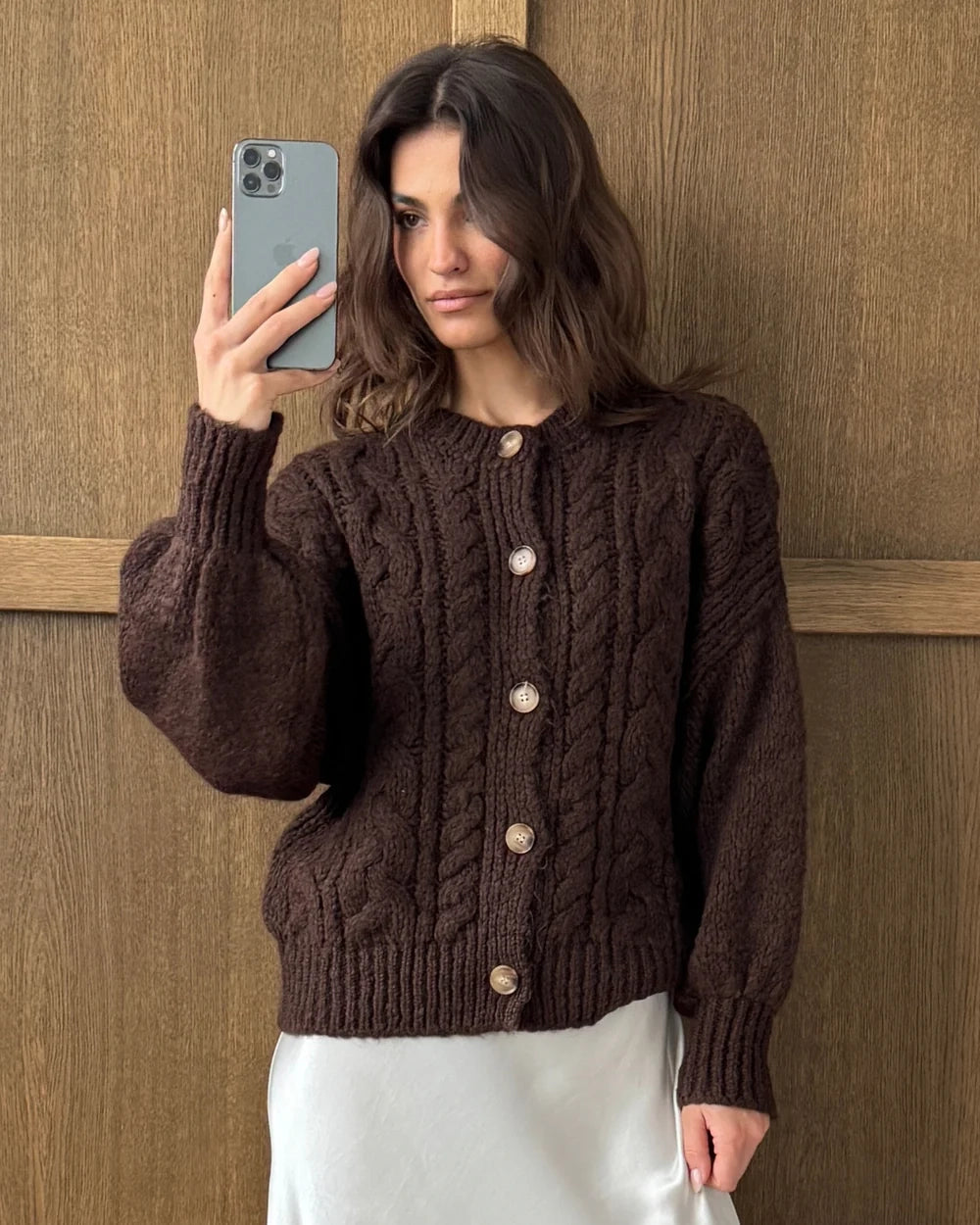 Woman wearing a brown cable knitted cardigan with large horn buttons