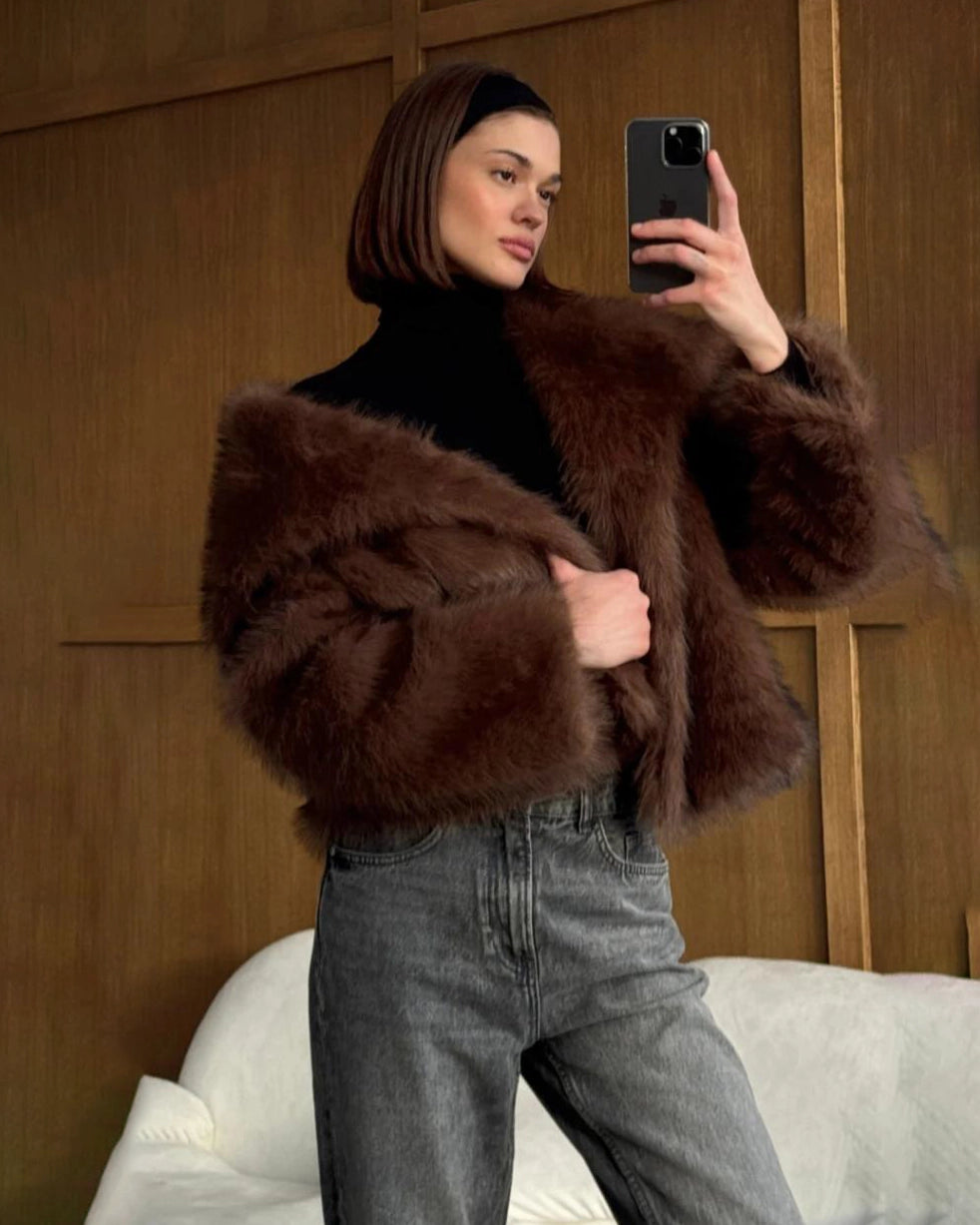 a woman wears a faux fur coat in brown with big lapels