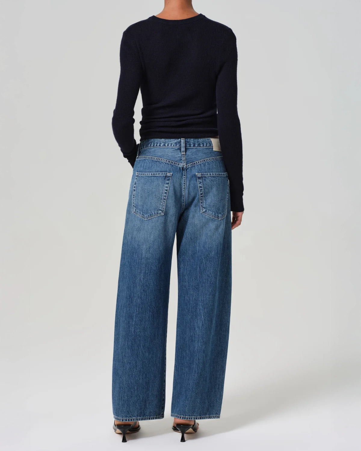 A person standing wearing wide leg blue denim jeans with a drawstring waist by Citizens of Humanity