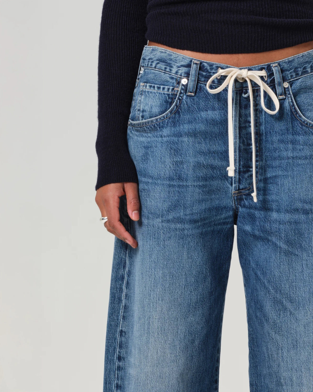 A person standing wearing wide leg blue denim jeans with a drawstring waist by Citizens of Humanity