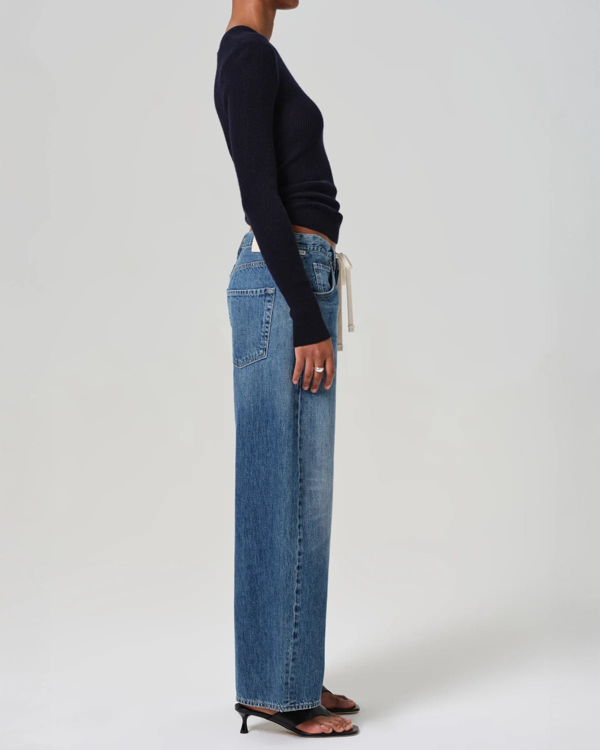 A person standing wearing wide leg blue denim jeans with a drawstring waist by Citizens of Humanity