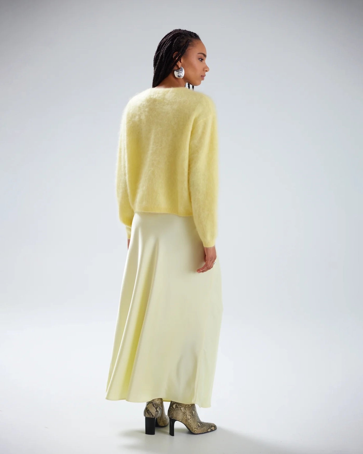 Woman wearing a light yellow brushed cashmere button down cardigan