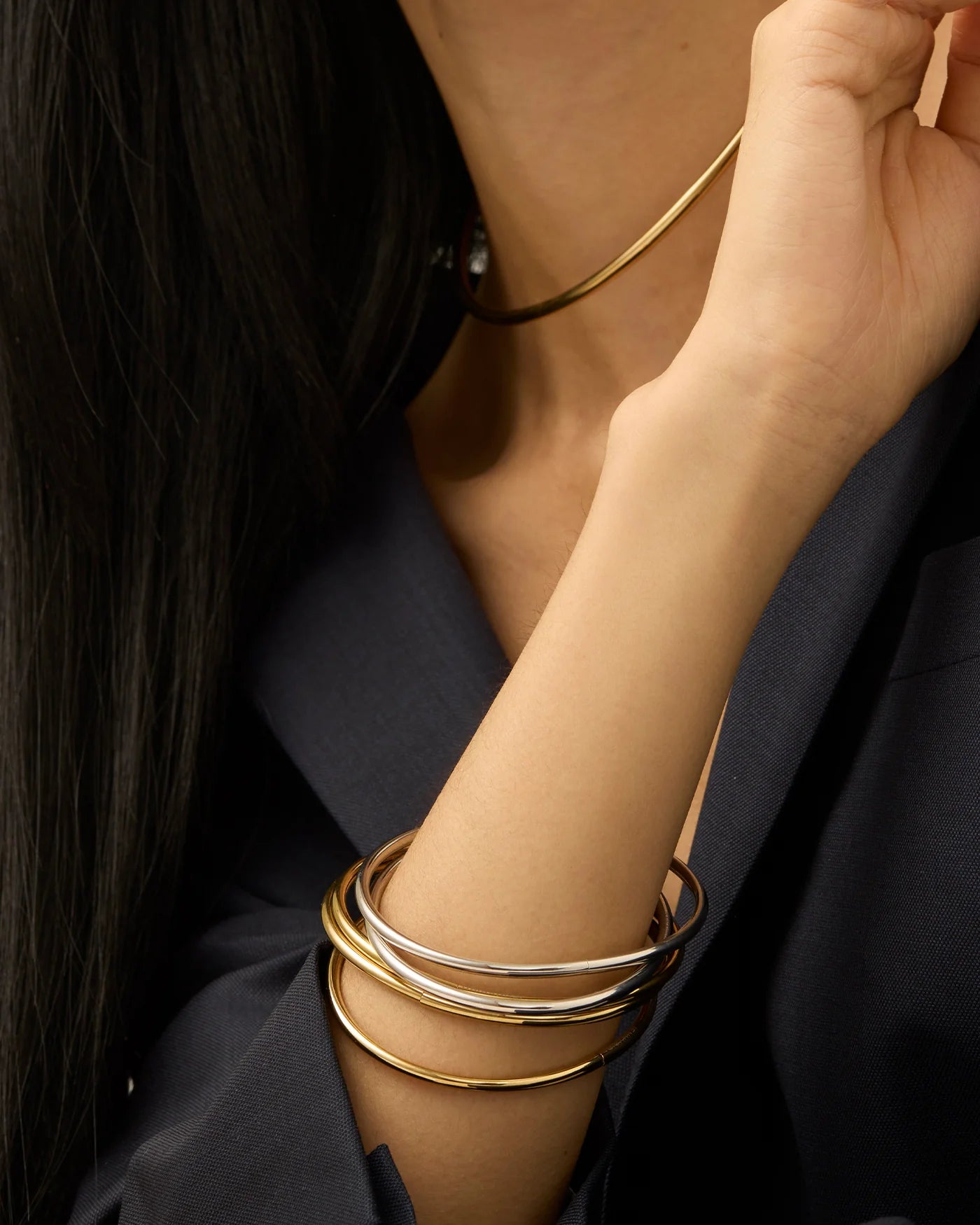 Gold and silver bangles bracelets on a person's wrist