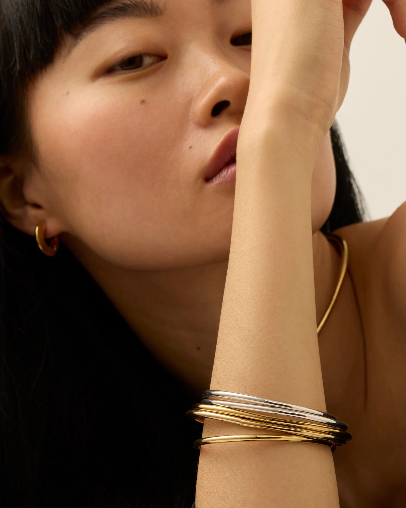 Gold and silver bangles bracelets on a person's wrist