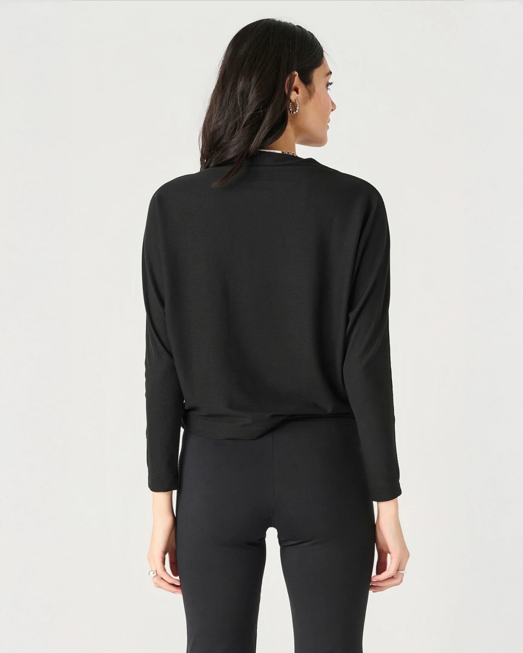 Woman wearing a ribbed mock neck top in black