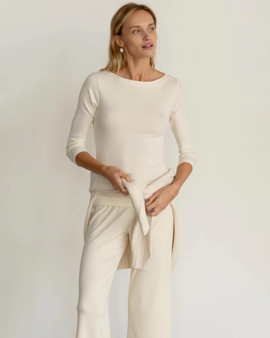 a woman wearing a ribbed boatneck top in cream
