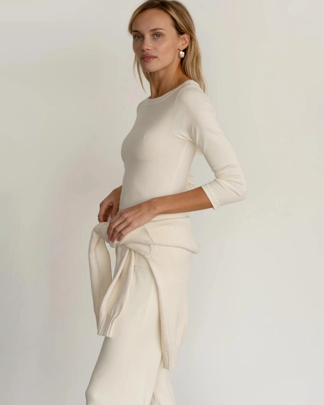 a woman wearing a ribbed boatneck top in cream