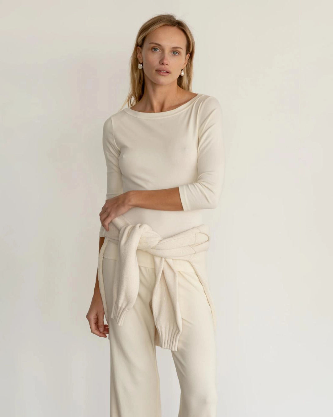 a woman wearing a ribbed boatneck top in cream