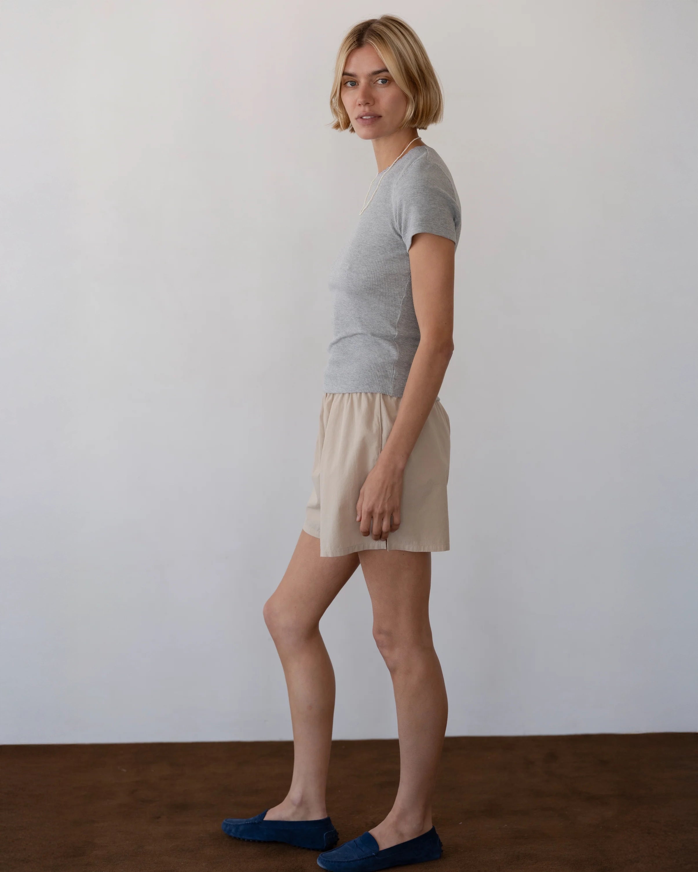 Person wearing beige cotton boxer shorts with grey t-shirt