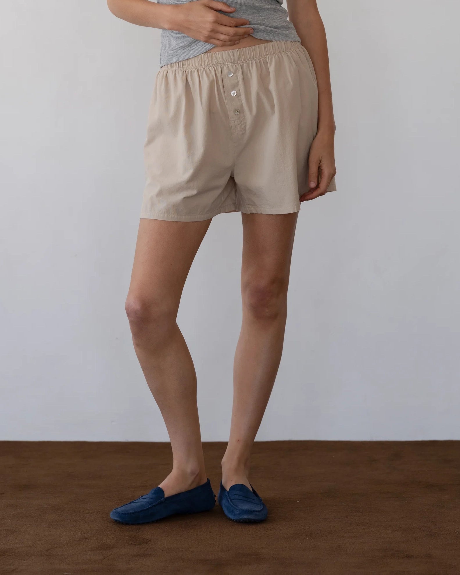Person wearing beige cotton boxer shorts