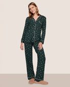 Woman wearing a dark green pajama set with a holiday dog pattern