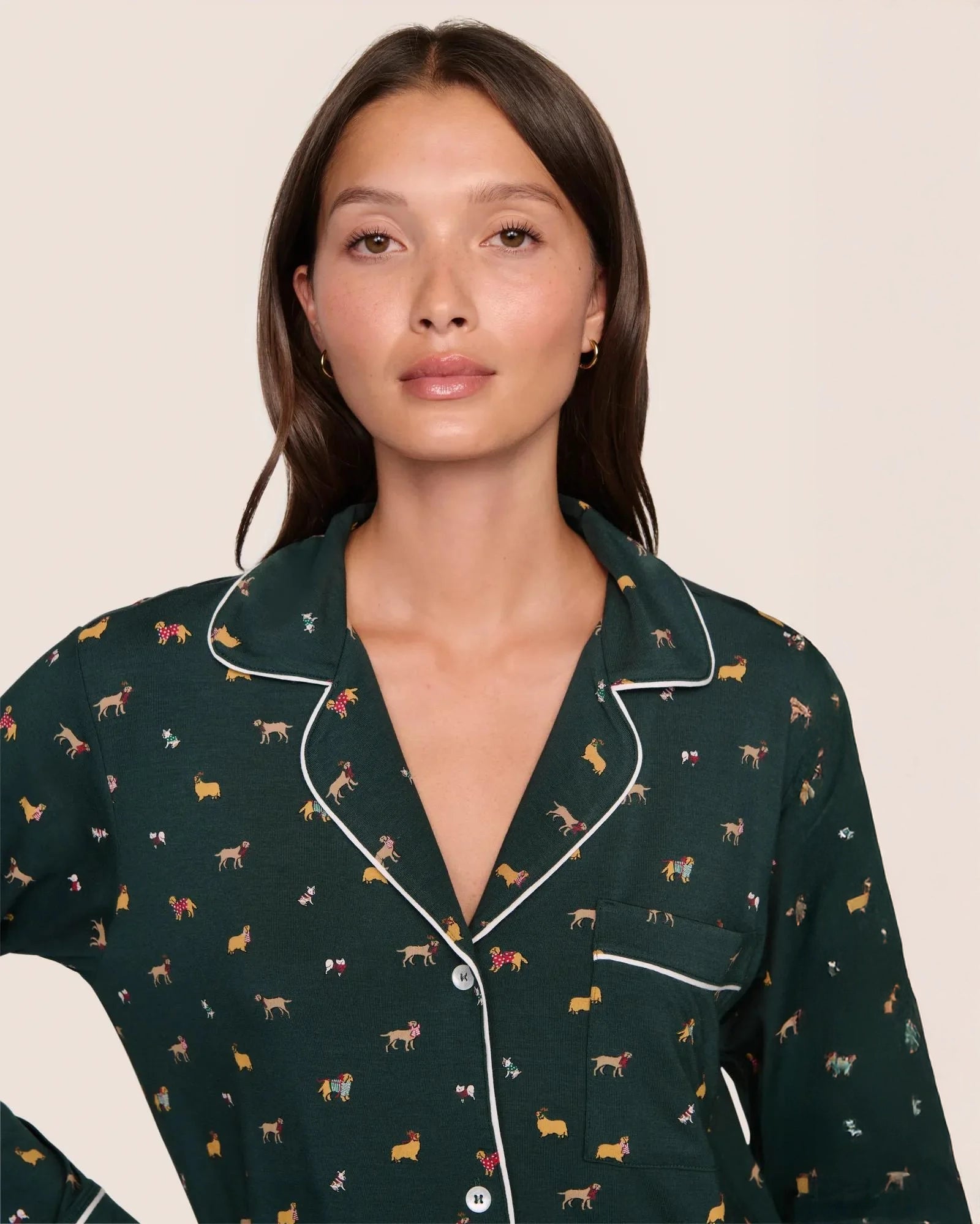 Woman wearing a dark green pajama set with a holiday dog pattern