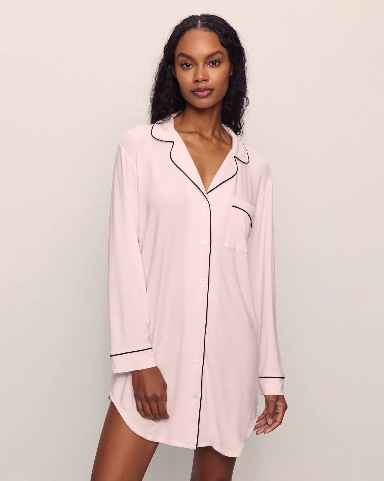 Woman wearing a pink pajama sleep shirt top black piping