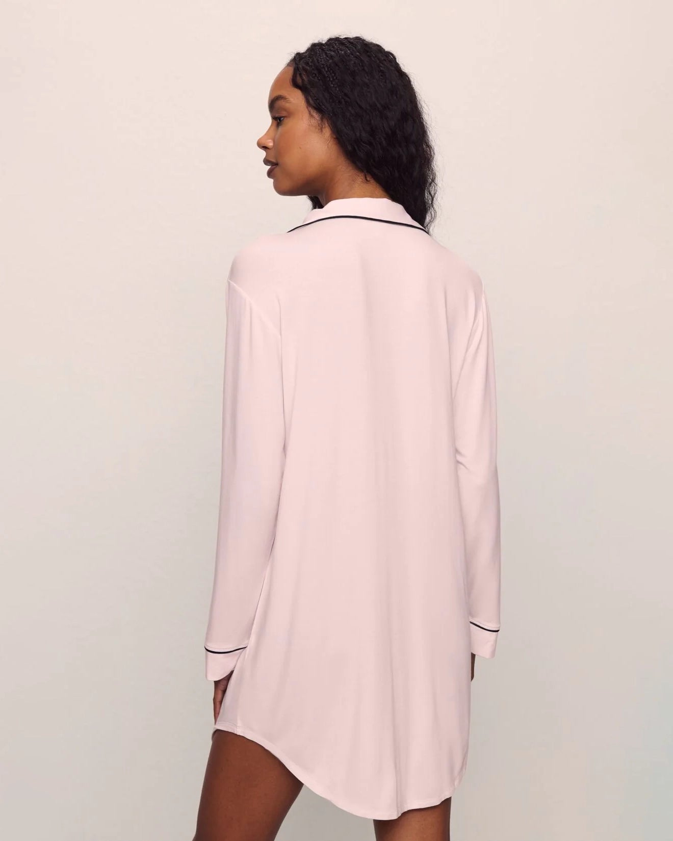 Woman wearing a pink pajama sleep shirt top black piping