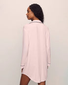 Woman wearing a pink pajama sleep shirt top black piping