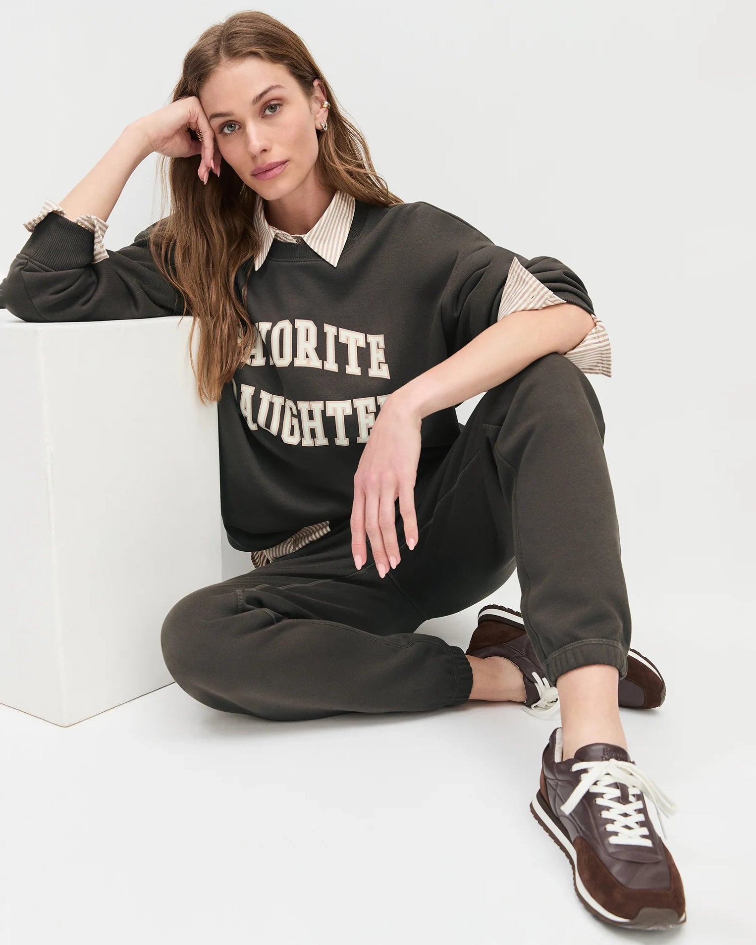 Woman wearing a sweatshirt with the words 'favourite daughter' in varsity letter on it