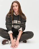 Woman wearing a sweatshirt with the words 'favourite daughter' in varsity letter on it