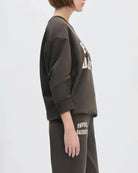 Woman wearing a sweatshirt with the words 'favourite daughter' in varsity letter on it