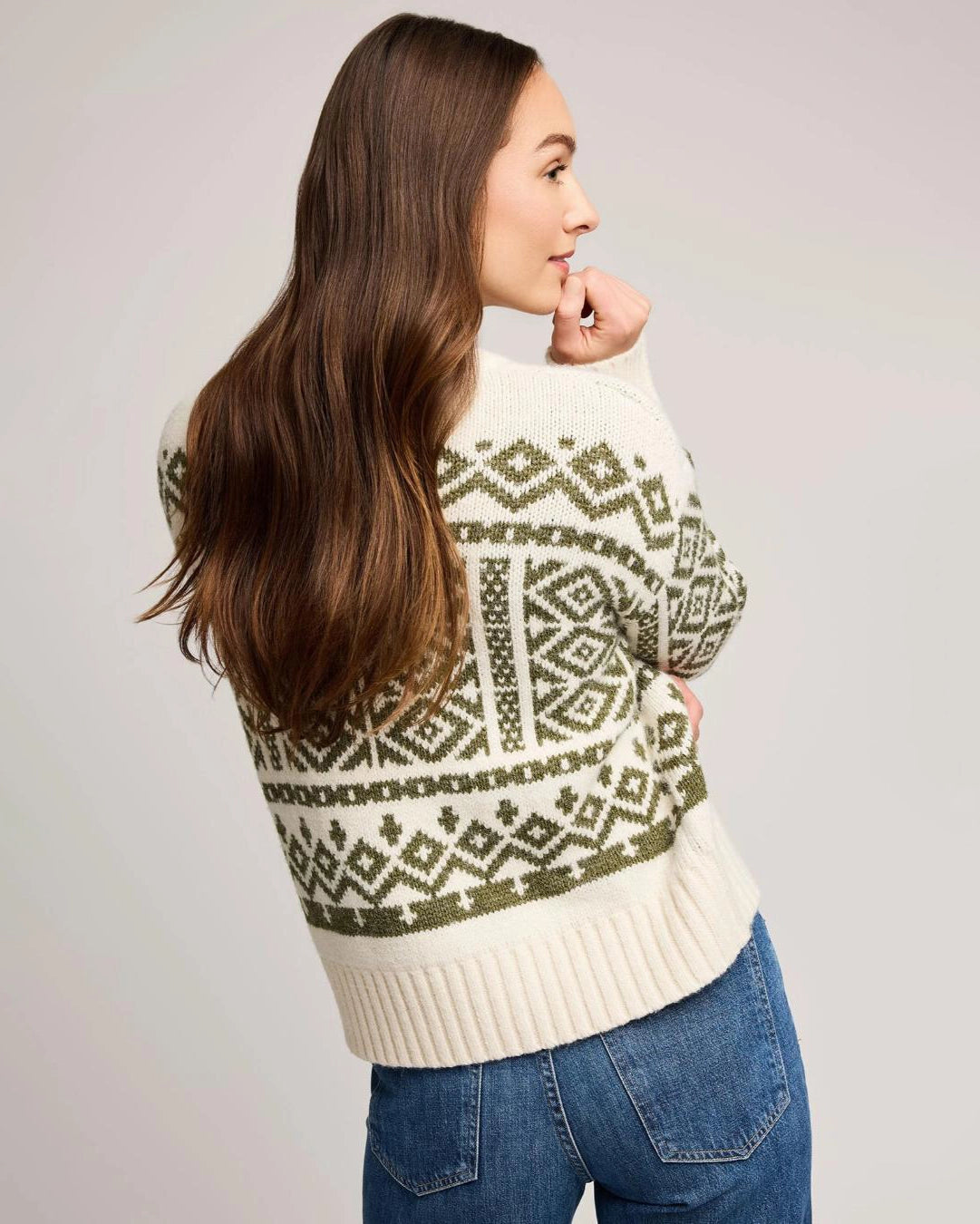 woman wearing a geometric fairisle holiday sweater in cream and green