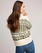 woman wearing a geometric fairisle holiday sweater in cream and green
