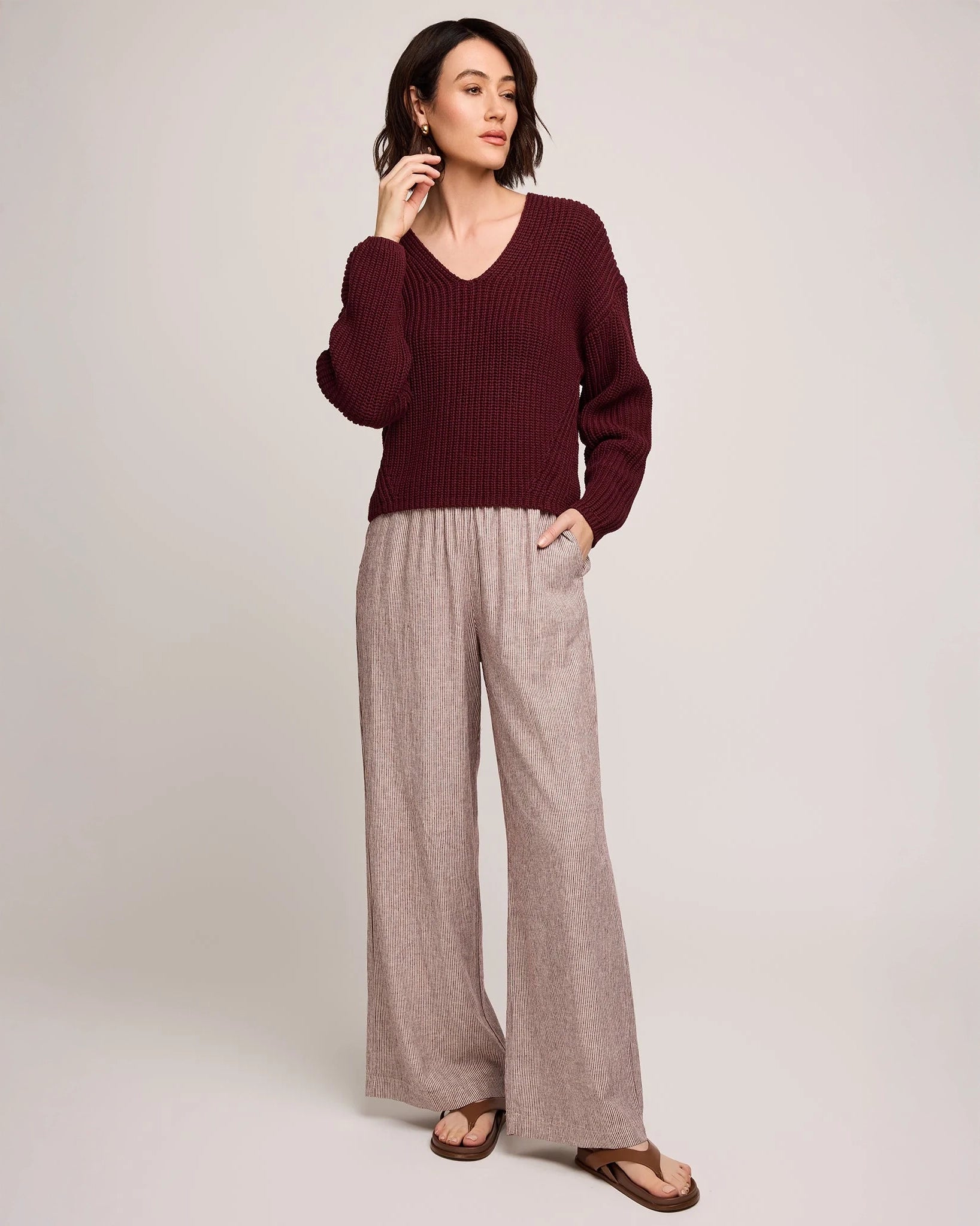 Person wearing burgundy stripe wide-leg linen pants