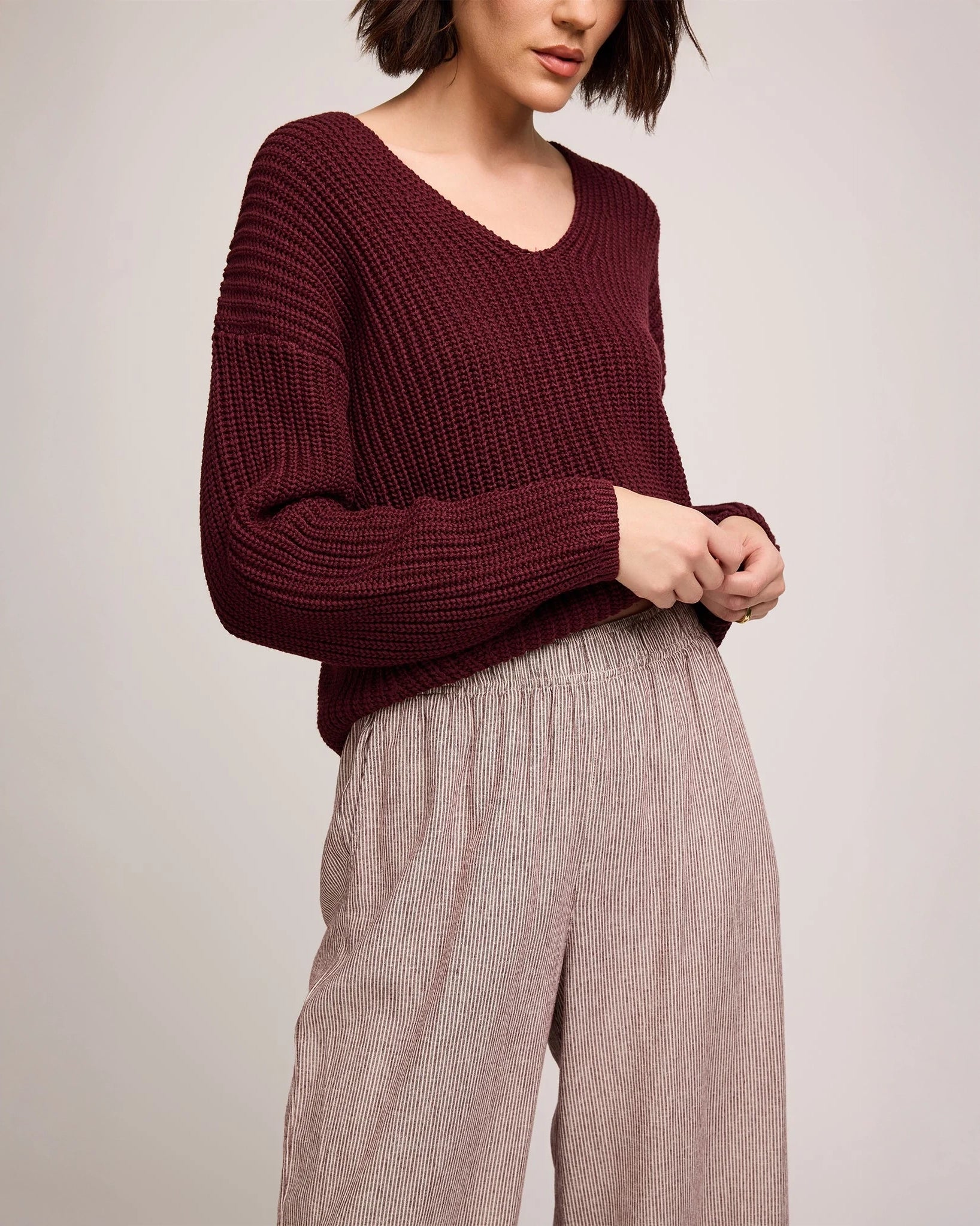Person wearing burgundy stripe wide-leg linen pants