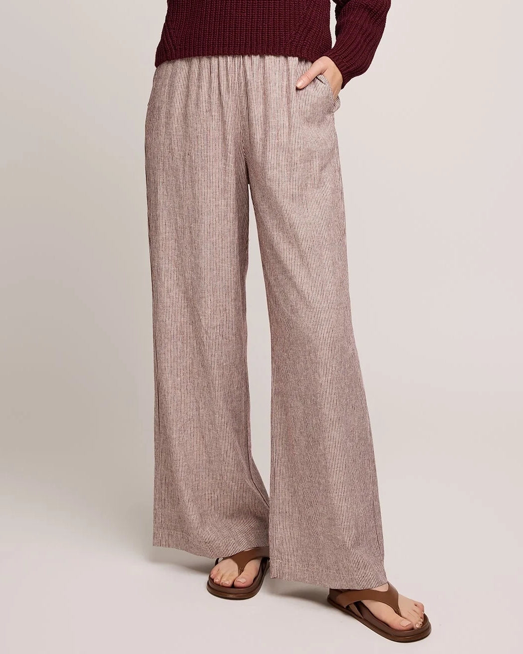 Person wearing burgundy stripe wide-leg linen pants