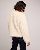 woman wearing a faux fur jacket in cream