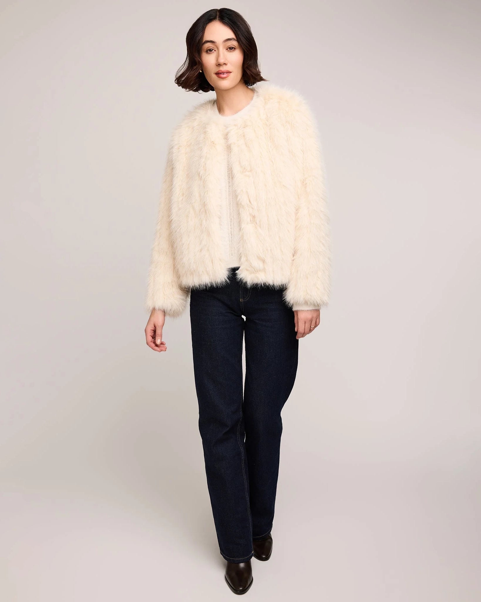woman wearing a faux fur jacket in cream